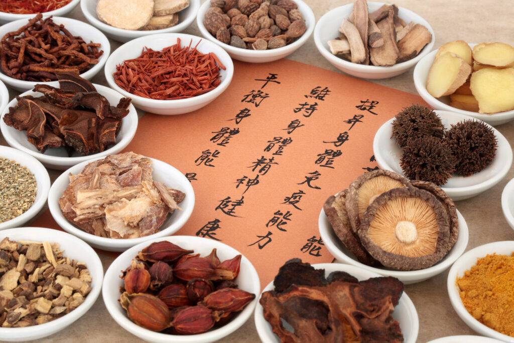 Traditionelle chinesische Kräuterauswahl, die in der Kräutermedizin verwendet wird. Die Übersetzung der Kalligrafieschrift beschreibt die medizinischen Funktionen, um die Gesundheit von Körper und Geist zu erhalten und die Energie auszugleichen.