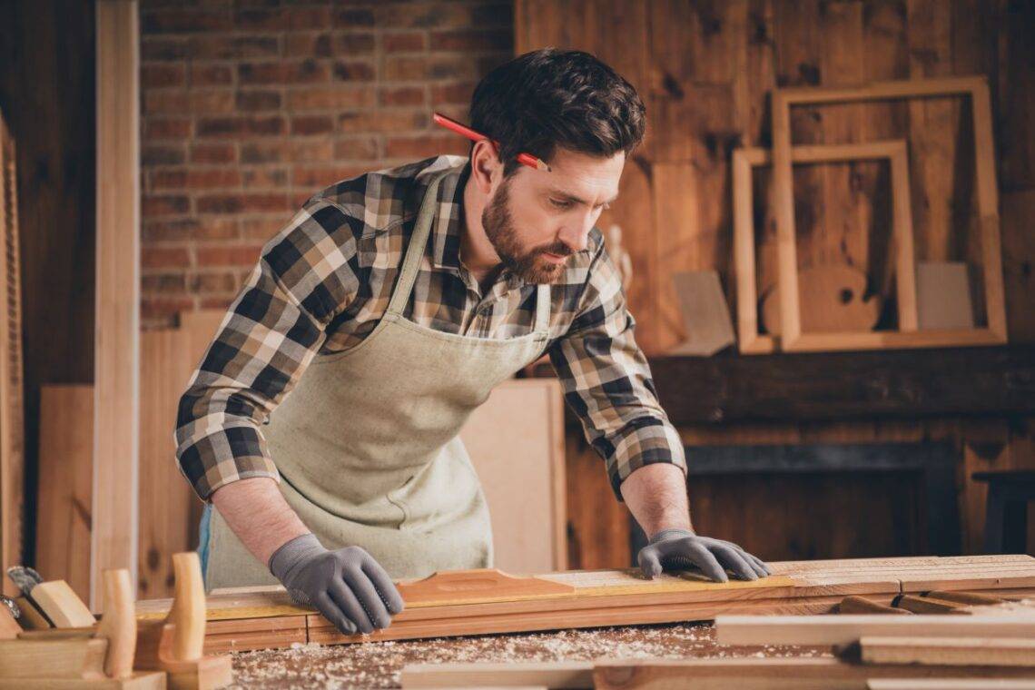 Möbelbauer in einer Werkstatt konzentriert bei der Arbeit, um maßgeschneiderte Möbelstücke in Berlin anzufertigen – Berlin Möbelbau