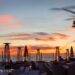 Sonnenuntergang auf Ibiza mit Blick auf ein Restaurant Ibiza, stilvolle Heizstrahler, Palmen und einem malerischen Himmel in warmen Farben