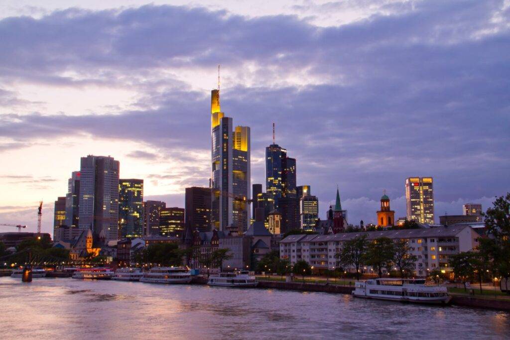 Abendliche Skyline von Frankfurt mit Mainufer, zeigt den Standortvorteil für Escort werden Frankfurt