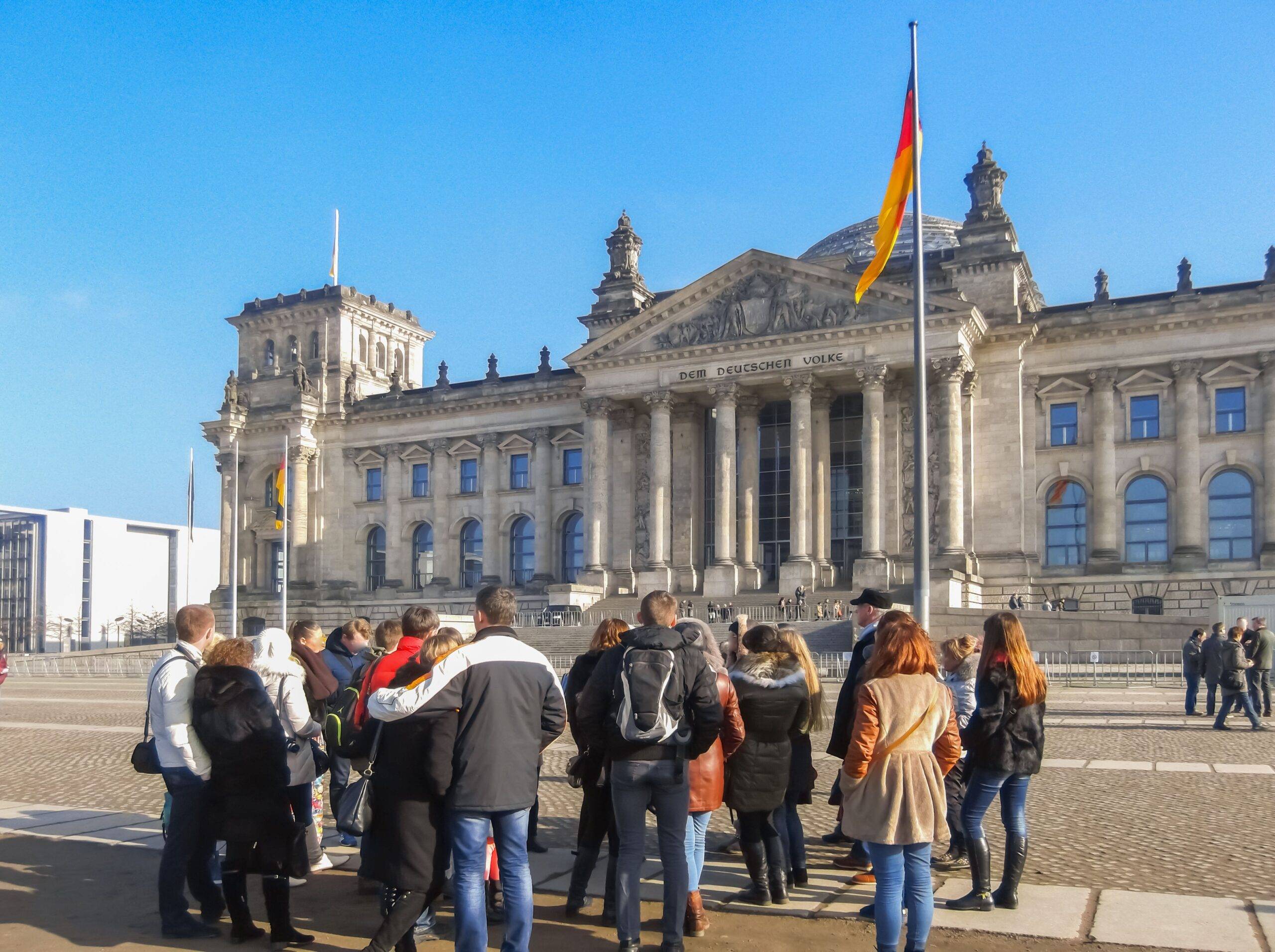 Schulklasse bei einer Führung vor dem Reichstagsgebäude während einer Klassenfahrt Berlin