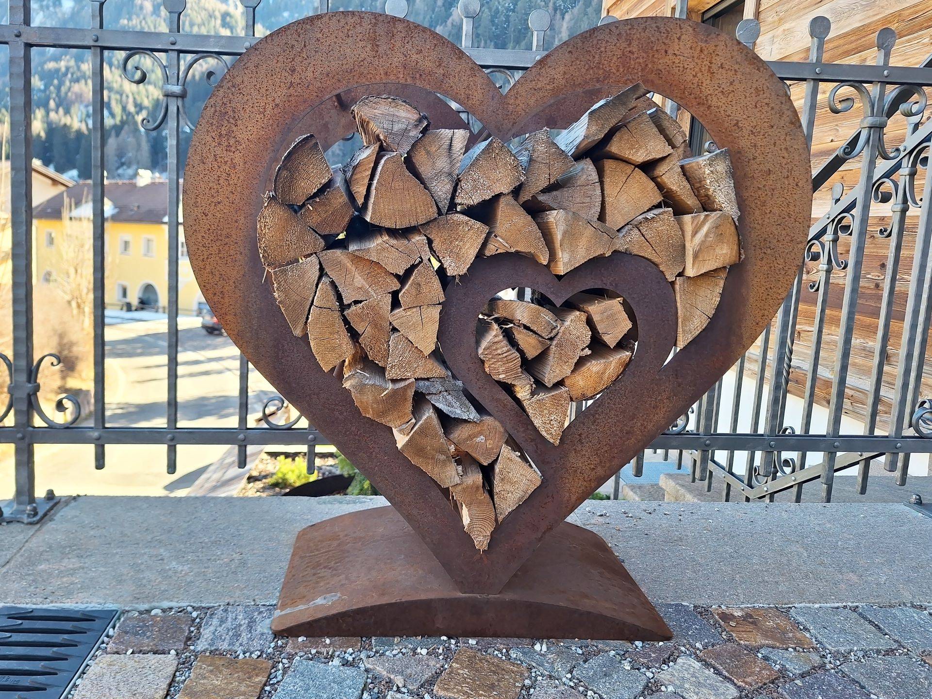 Herzförmiges Metallregal mit Kaminholz