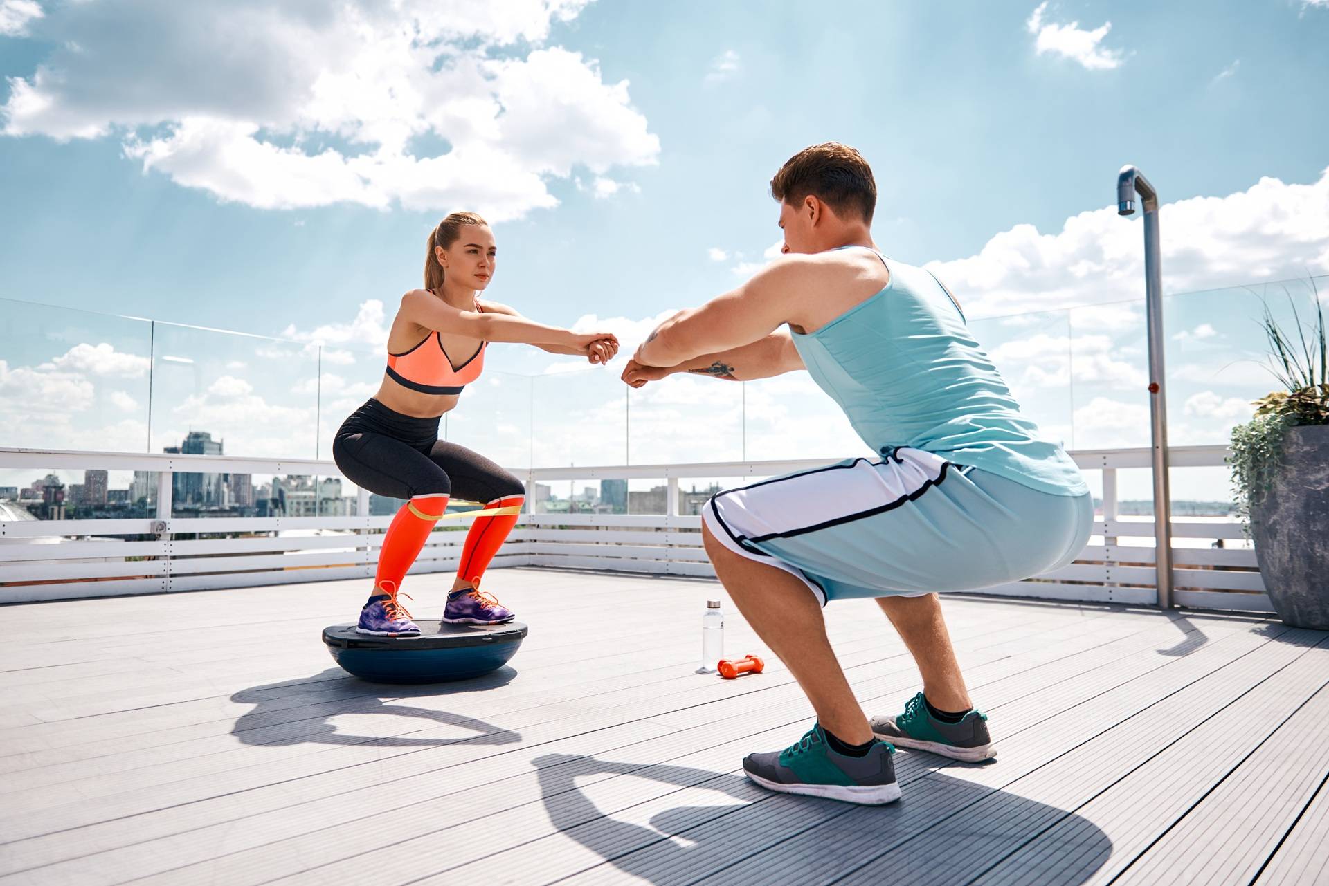 Fitnessuebung auf Balanceboard mit Trainer | Orthopäde Köln