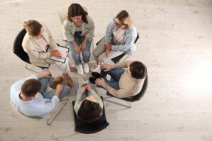 Menschen sitzen im Stuhlkreis und besprechen Themen – Ausbildungssituation für soziale Berufe