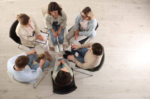 Menschen sitzen im Stuhlkreis und besprechen Themen – Ausbildungssituation für soziale Berufe