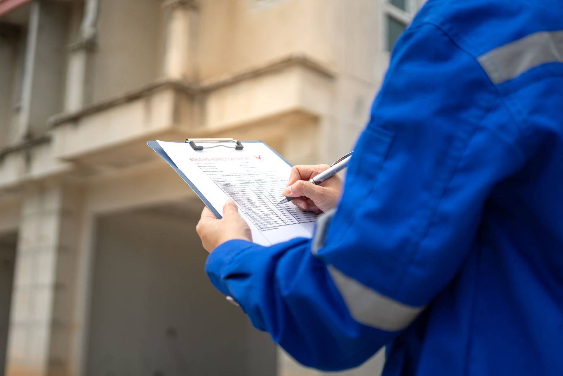 Schadstoffgutachter fuellt Checkliste bei der Gebaeudeinspektion vor Ort aus